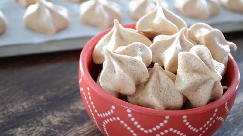 Crispy maple meringues in a red bowl with more cooling on a tray in the background