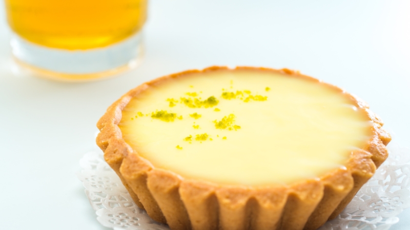 A golden tart filled with smooth maple cream and topped with a sprinkle of crushed walnuts